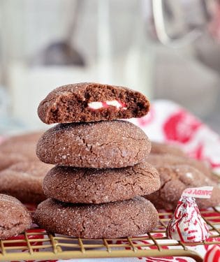 Super soft chocolate cookies hold a peppermint kiss in the center in these Peppermint Surprise Crinkle Cookies. Find the recipe at TidyMom.net