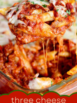 large serving spoonful of baked mostaccioli with pulls of melted cheese