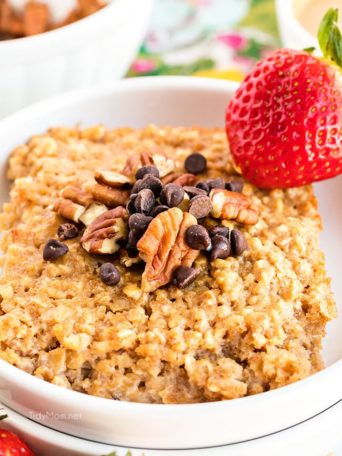 bowl of baked peanut butter oatmeal topped with chocolate chips and pecans