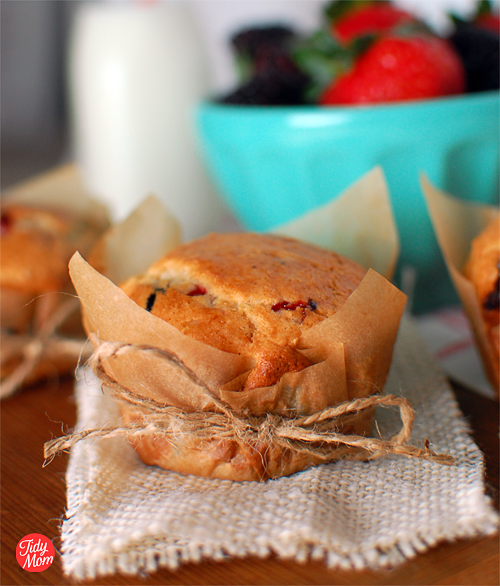 Crisp parchment paper wrappers give these MIXED BERRY MUFFINS a just from the bakery feel.  Get the muffin recipe and wrapper tutorial at TidyMom.net