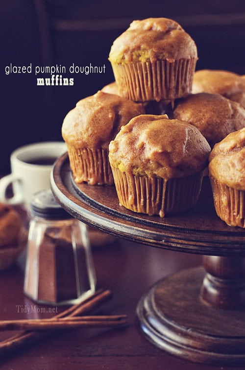 Glazed Pumpkin Doughnut Muffins are baked and then coated with a pumpkin glaze to tastes just like a doughnut! I love how much the pumpkin flavor shines through these pumpkin muffins.  With their dense 'cake doughnut' texture, that's not overly sweet,  it's perfect with a double dip of pumpkin glaze on top. Print the full recipe at TidyMom.net #pumpkin #muffin #tidymom #doughnut #donut