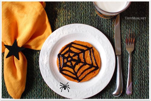 Spooky Pumpkin Pancakes with Black Cinnamon Syrup. Eating these pumpkin pancakes is so much more fun when you can draw your own design with the black cinnamon syrup. Click to get the pancake and syrup recipes at TidyMom.net