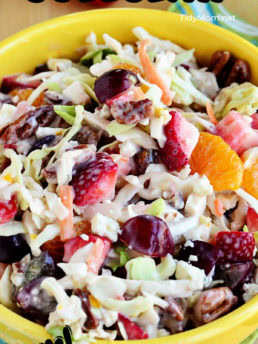 coleslaw with fruit and nuts in a yellow bowl