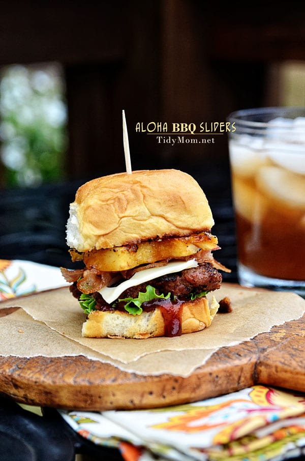 Fire up the grill for this Hawaiian burger recipe. Aloha BBQ Sliders are flavored with BBQ sauce, served on sweet rolls with cheese, pineapple and bacon. Aloha BBQ Sliders recipe at TidyMom.net