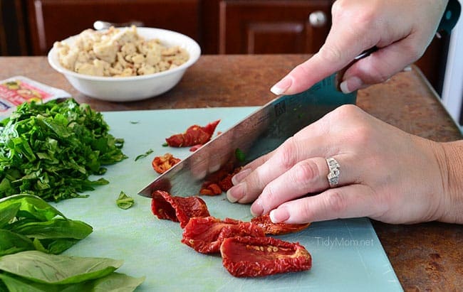 Chopping vegetables for Pizza Bread. Recipe at TidyMom.net