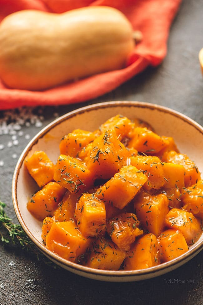 maple braised butternut squash in a bowl seasoned with fresh thyme in a bowl