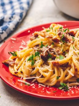 Delicious classic Bacon Carbonara on a red plate