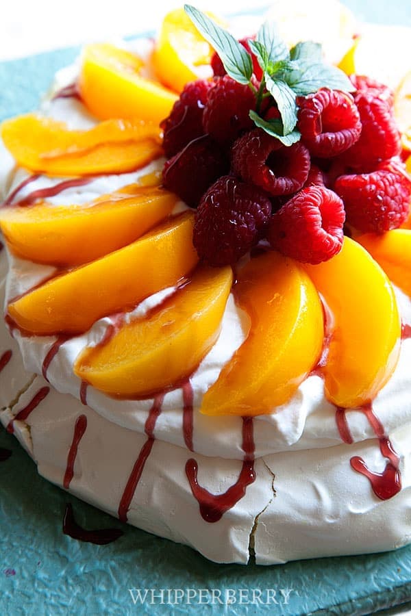 Peach Melba Pavlova topped with fresh summer fruit