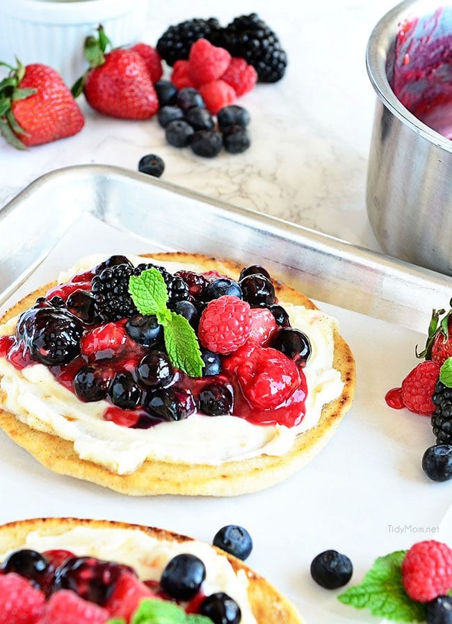 Berry Breakfast pizza tastes as good as it looks! It's impossible to resist the toasted flatbread crust, rich orange mascarpone layer and glossy berry topping. It's so convenient to prepare the night before and serve the next morning, or any time of day! Full recipe at TidyMom.net