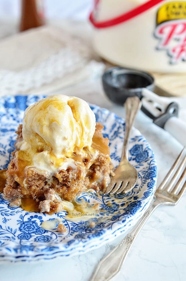 Easy Cinnamon Roll Poke Cake on a plate and topped with a scoop of vanilla ice cream
