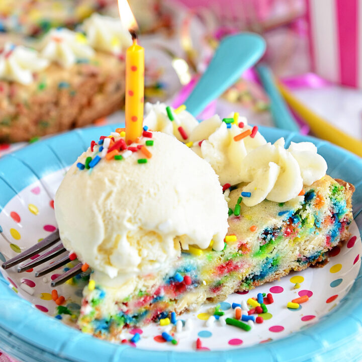 slice of cookie cake with ice cream and a candle