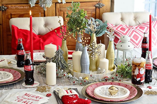 Use empty Cocoa Cola bottles as a pretty holiday table centerpiece. Just paint with glitter spray paint and add some holiday florals, and arrange on a tray. Easy and costs almost nothing! details at TidyMom.net