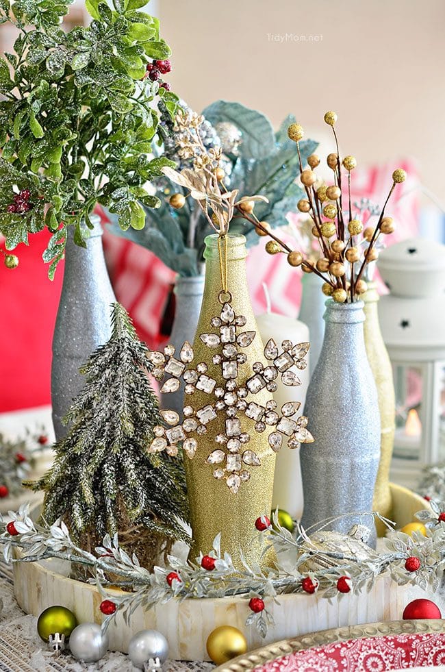 Use empty Cocoa Cola bottles as a pretty holiday table centerpiece. Just paint with glitter spray paint and add some holiday florals, and arrange on a tray. Easy and costs almost nothing! details at TidyMom.net