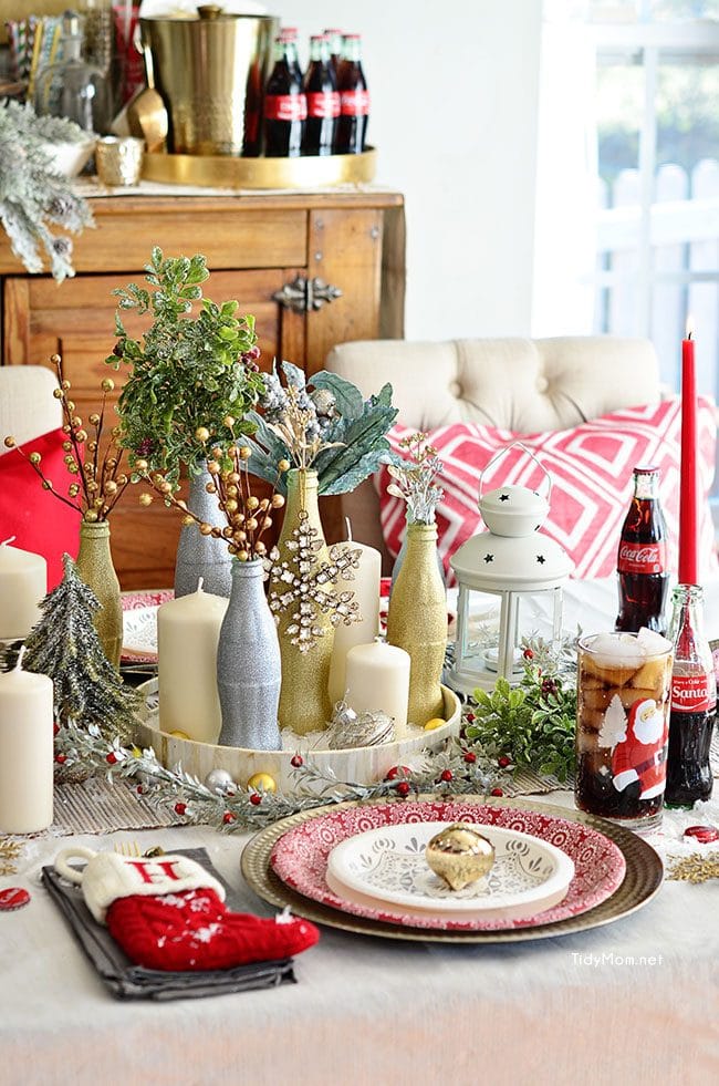 Use empty Cocoa Cola bottles as a pretty holiday table centerpiece. Just paint with glitter spray paint and add some holiday florals, and arrange on a tray. Easy and costs almost nothing! details at TidyMom.net