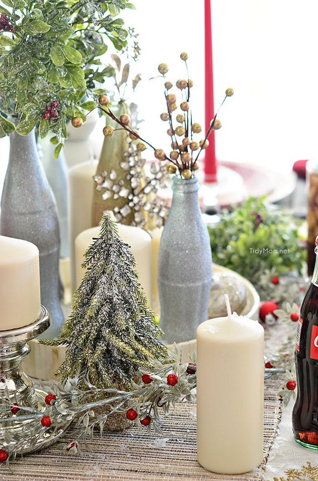 Use empty Cocoa Cola bottles as a pretty holiday table centerpiece. Just paint with glitter spray paint and add some holiday florals, and arrange on a tray. Easy and costs almost nothing! details at TidyMom.net