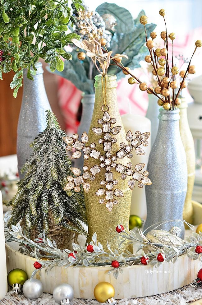 Use empty Cocoa Cola bottles as a pretty holiday table centerpiece. Just paint with glitter spray paint and add some holiday florals, and arrange on a tray. Easy and costs almost nothing! details at TidyMom.net