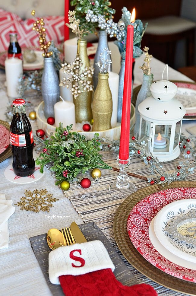 Use empty Cocoa Cola bottles as a pretty holiday table centerpiece. Just paint with glitter spray paint and add some holiday florals, and arrange on a tray. Easy and costs almost nothing! details at TidyMom.net