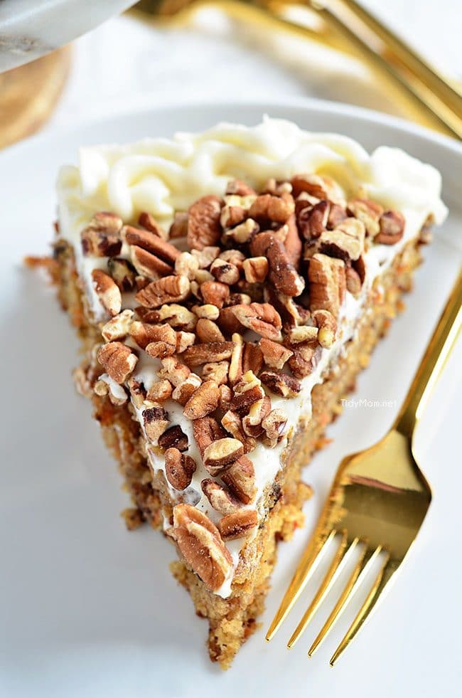 close up of a piece of carrot cake with pecans on top