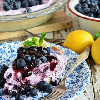 Blueberry Yogurt Pie is the perfect dessert for summer! This pie starts off with a simple shortbread crust filled filled with yogurt and blueberries then topped off with lemon blueberry fruit spread.