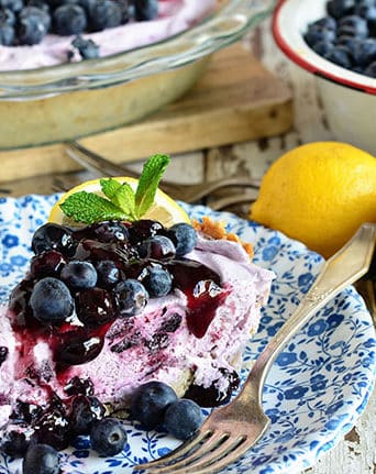 Blueberry Yogurt Pie is the perfect dessert for summer! This pie starts off with a simple shortbread crust filled filled with yogurt and blueberries then topped off with lemon blueberry fruit spread.