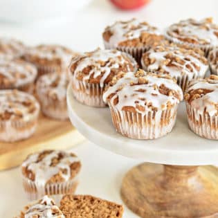 These Apple Spice muffins with Struesel Topping have a suprise ingredient that packs them with fiber!! Applesauce, spices, baked beans, crumb topping, vanilla glaze combine to create a delicious breakfast treat or afternoon snack. Bake a batch and enjoy the warm fall flavors! muffin recipe at TidyMom.net