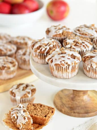 These Apple Spice muffins with Struesel Topping have a suprise ingredient that packs them with fiber!! Applesauce, spices, baked beans, crumb topping, vanilla glaze combine to create a delicious breakfast treat or afternoon snack. Bake a batch and enjoy the warm fall flavors! muffin recipe at TidyMom.net