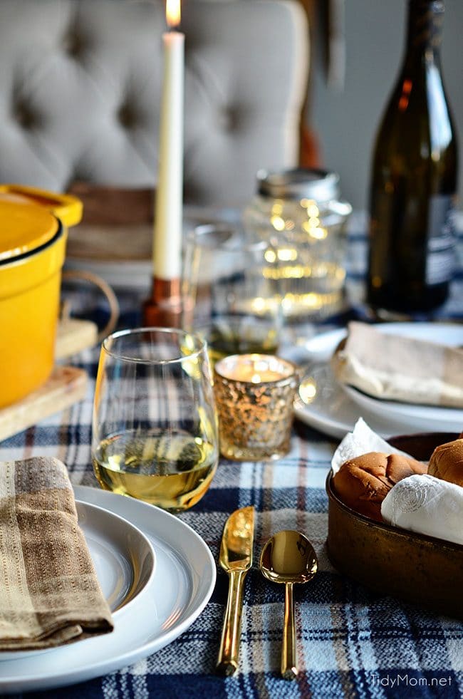 Set a simple cozy dinner table with a blanket, candles, lights and music.