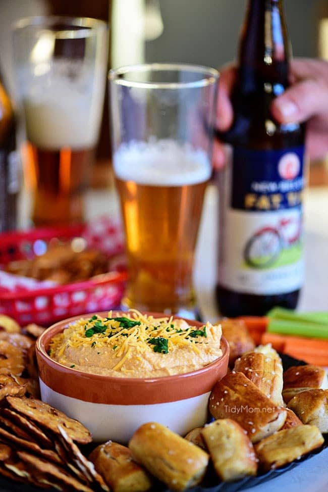 Salsa de queso de cerveza estilo Pub con pretzel y un vaso de cerveza.