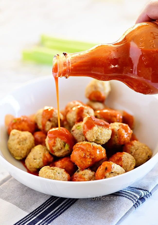 drizzling sauce over Chicken Meatballs 