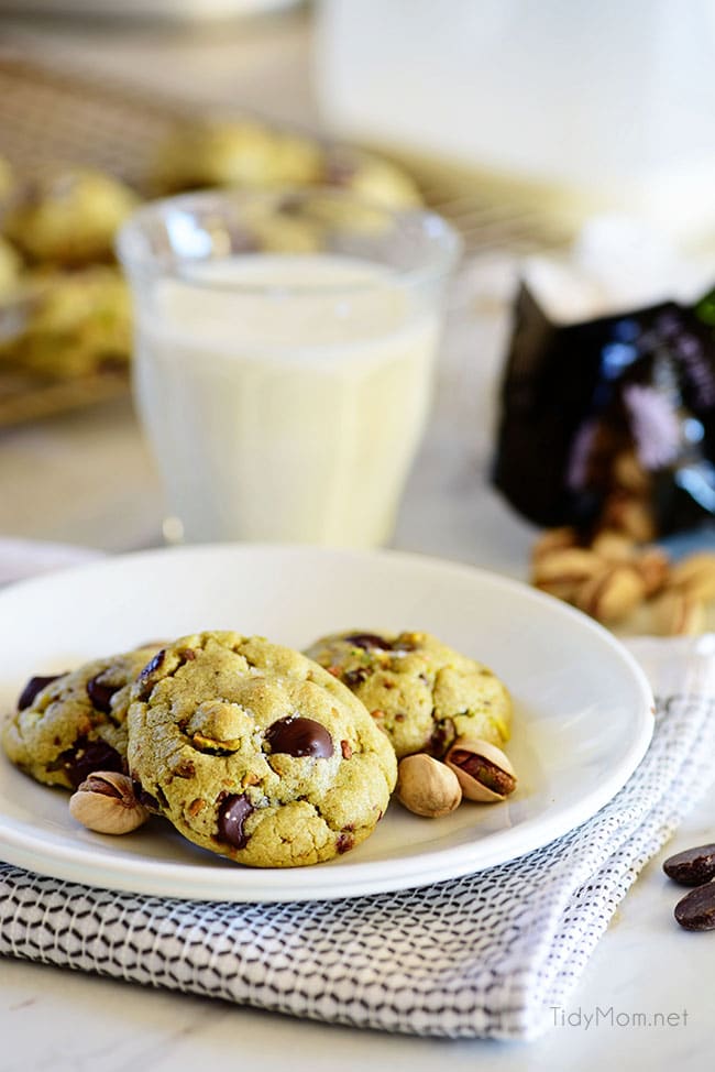 Pistachio cookies on a plate with a glass of milk