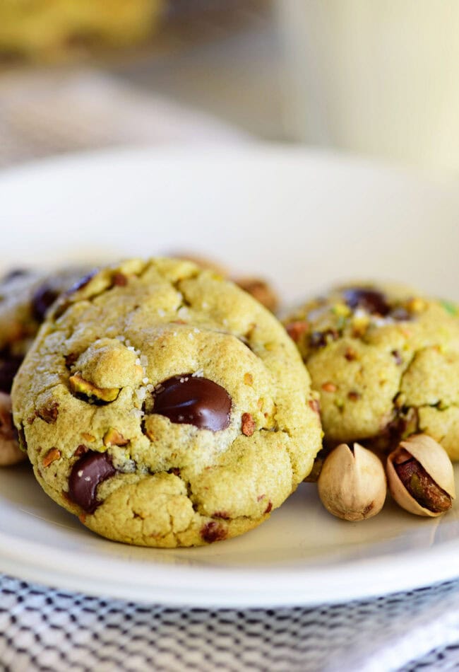 green pistachio pudding cookies with dark chocolate chips on a white plate