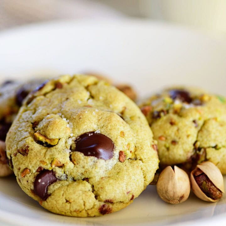 green pistachio pudding cookies with dark chocolate chips on a white plate