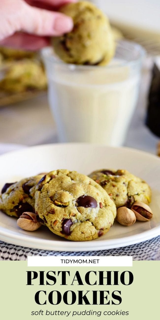 pistachio cookies on a plate and one being dunked in milk