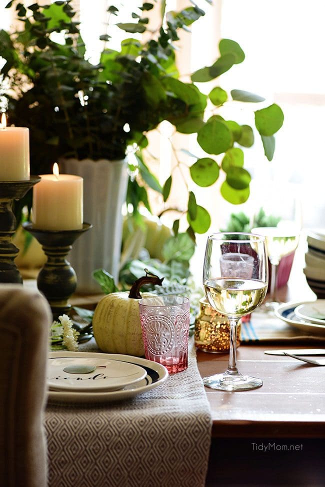 Set table with light candles: Seasonal Simplicity — Blue and Green Fall Tablescape with simple eucalyptus and pumpkins fall centerpiece . Get all the details along with 20+ Fall Home Tours at TidyMom.net