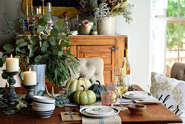 Seasonal Simplicity — Blue and Green Fall Tablescape with simple eucalyptus and pumpkins fall centerpiece . Get all the details along with 20+ Fall Home Tours at TidyMom.net 