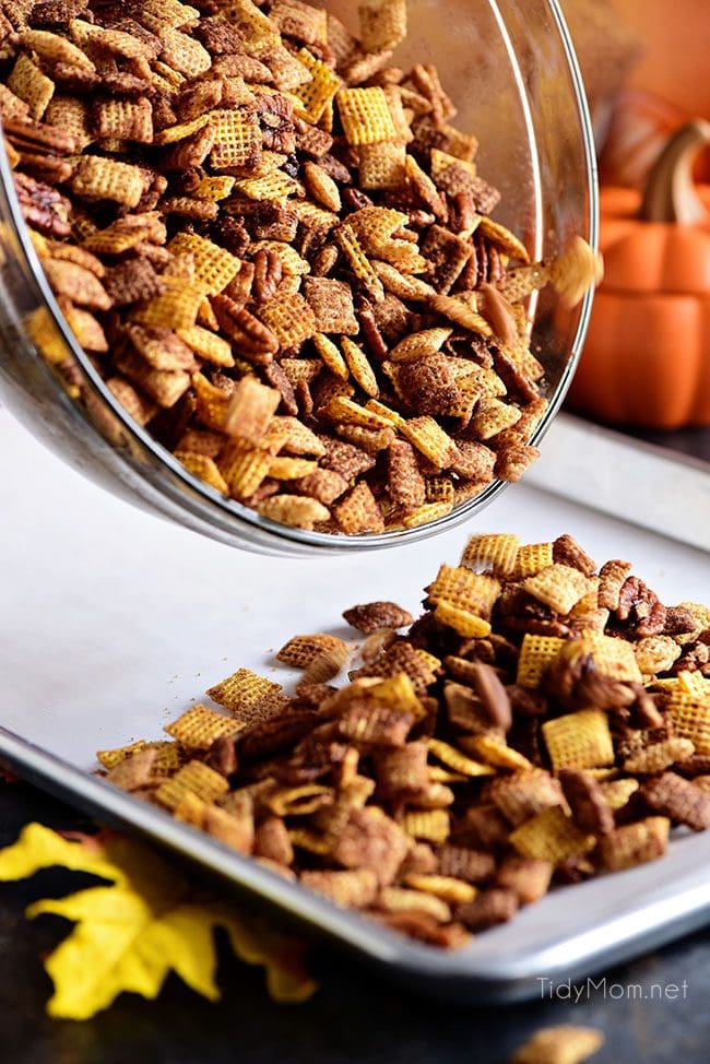 Pouring Pumpkin Spice Chex Mix on pan