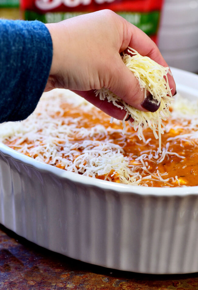 topping a casserole with shredded cheese