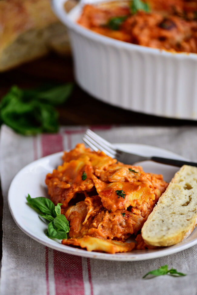 ravioli with red sauce on a plate with bread