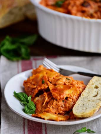 Cheesy Ravioli Bake Casserole with Chicken is easy to make and impossible to resist. Making it the perfect weeknight dish. Cheese ravioli, marinara sauce, chicken and lots of cheese, all layered and baked until bubbly and gooey! Print recipe + view short recipe video at TidyMom.net