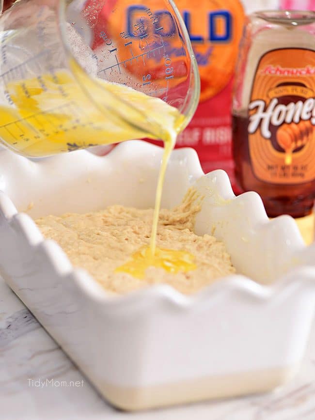 pouring melted butter over Hard Apple Cider Bread dough for a crisp crust