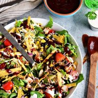 This BBQ Chicken Salad is super easy, can even be made with leftovers and it's off the hook delicious! Grilled corn and lime crema really make it sing! If you were a fan of Panera's BBQ Chicken Salad, you're going to love this copycat salad you can make in 15 minutes or less at home! Print the full recipe at TidyMom.net