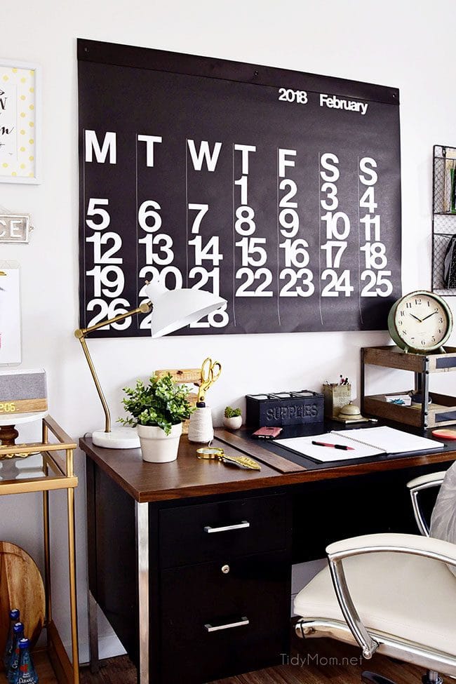 Decorating a shared home office, with colorful industrial style. Her side is pink and gold, while his is black and neutrals. Check out the gold coffee cart and Stendig wall calendar!! Get all the details of this shared home office space at TidyMom.net