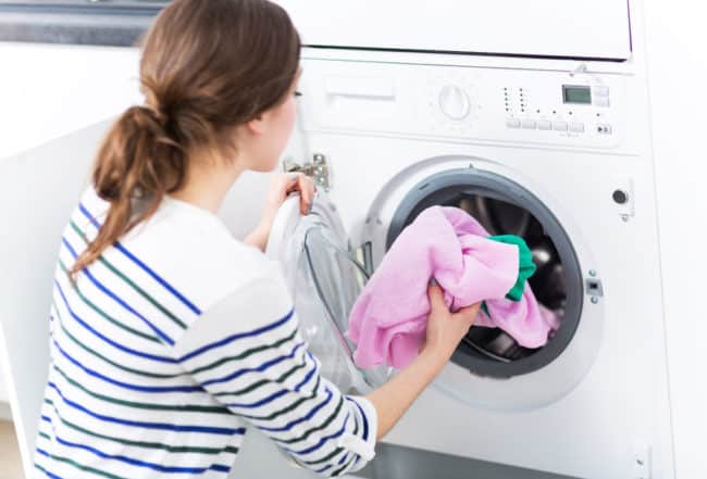woman putting clothes in laundry