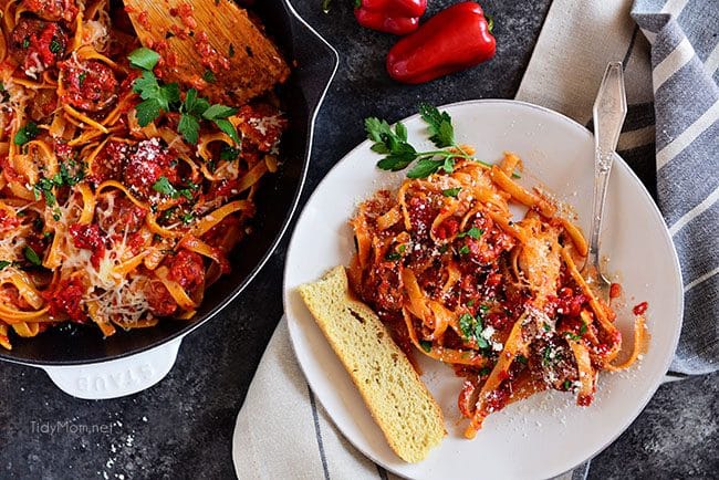 Roasted Red Pepper Fettuccine with Smoked Sausage on white plate