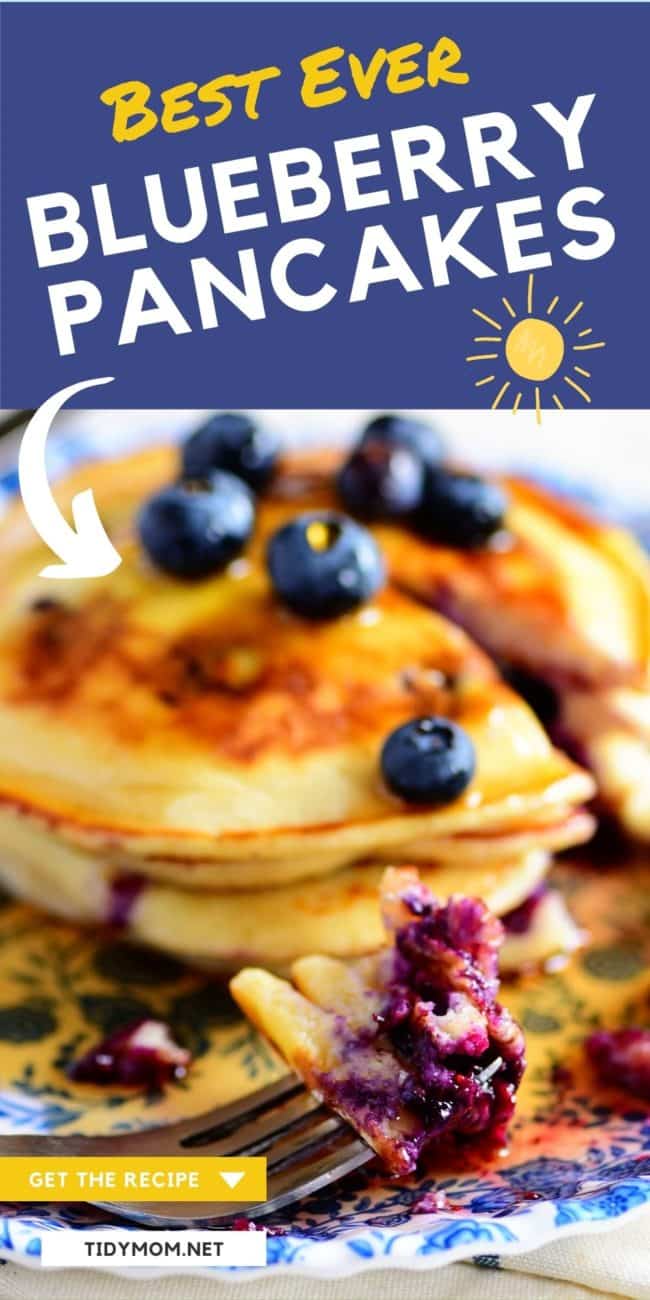 a stack of blueberry pancakes with a bite on a fork