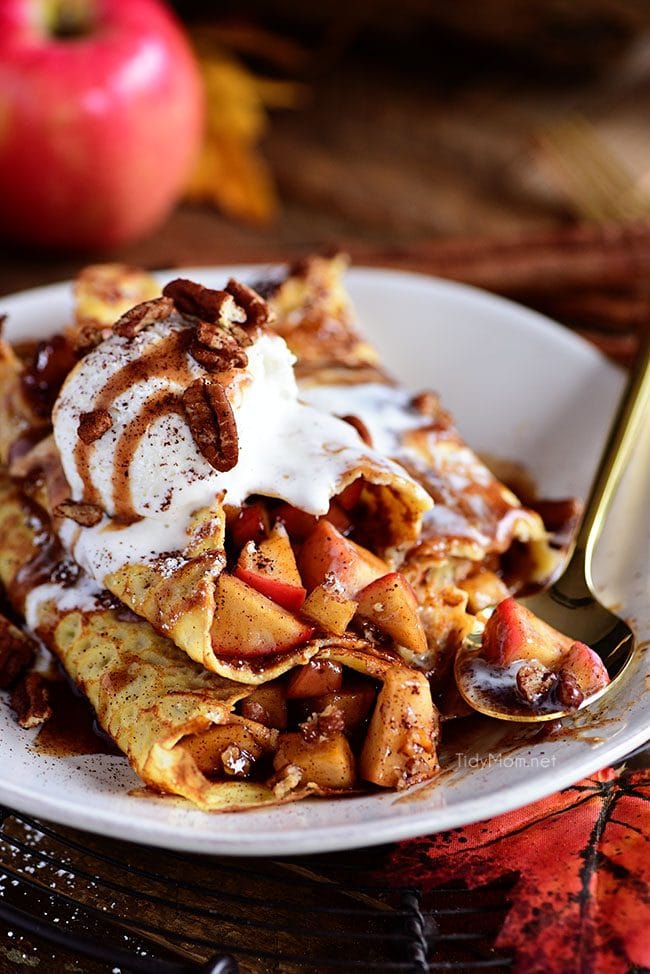 Apple Pie Crepes are thin french pancakes filled with a gooey caramel apple compote and toasted cinnamon pecans. Top with ice cream for the perfect dessert crepes.