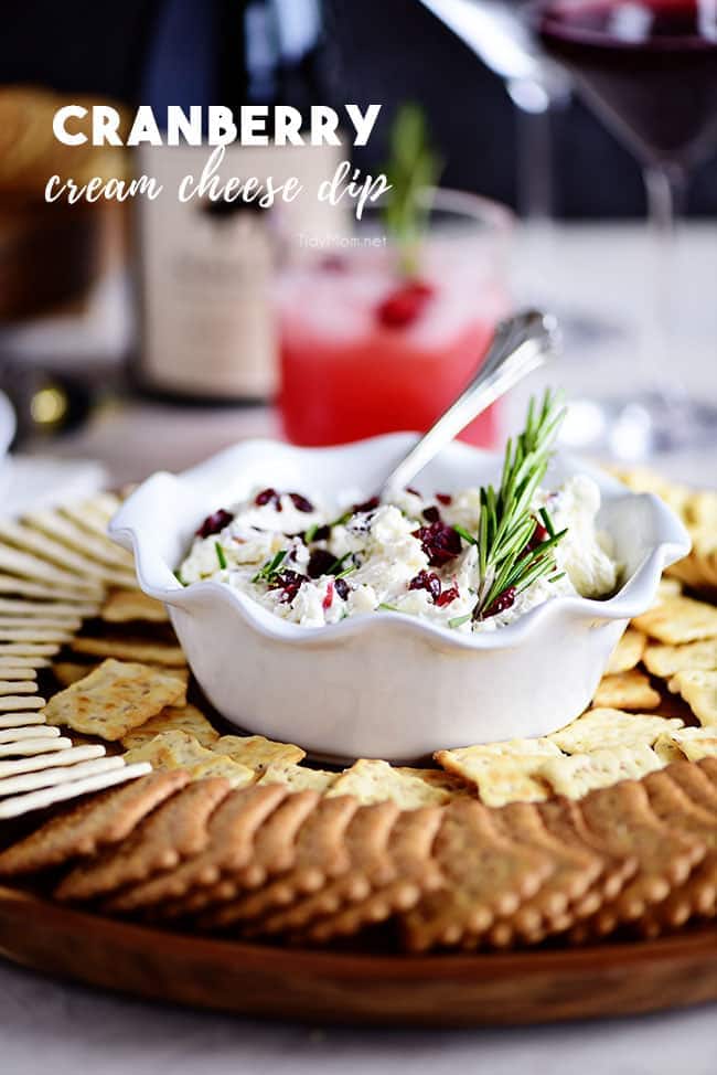 A beautifully presented Cranberry Cream Cheese Dip in a rustic bowl, garnished with fresh rosemary, ready to be served on a holiday platter