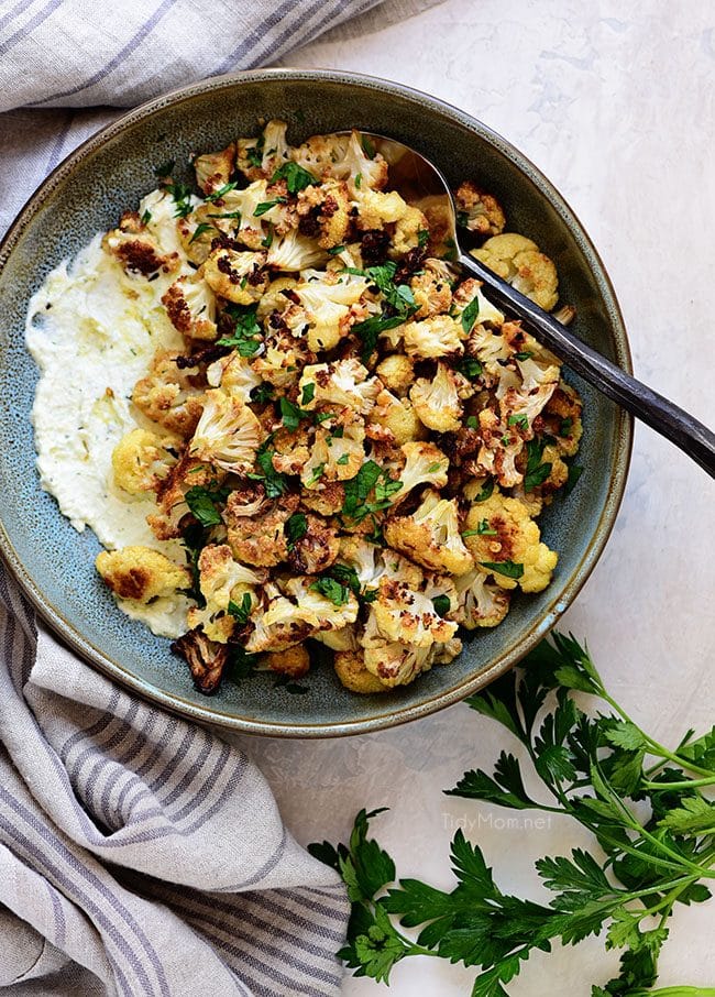 a bowl of Creamy Whipped Feta with fresh herbs and roasted cauliflower