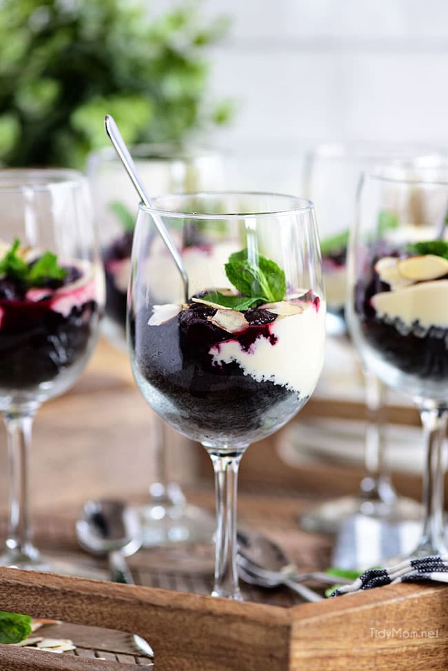 Cheesecake Parfaits with dark cherries in wine glasses