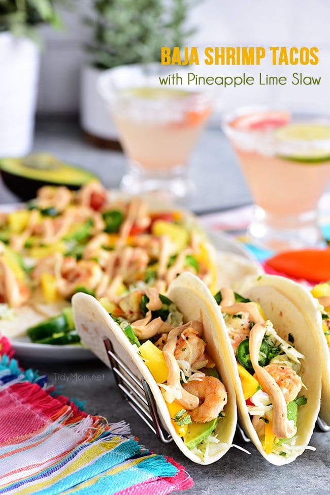 Pineapple lime slaw adds a nice tangy crunch to these Baja Shrimp Tacos. Loaded with garlic roasted shrimp, avocado, sweet peppers, tomatoes and spicy chipotle mayo making these the BEST shrimp tacos. The perfect quick and delicious meal any night of the week. Print full recipe at TidyMom.net #tacos #shrimp #tacotuesday
